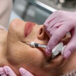 Older woman getting an injection near her mouth